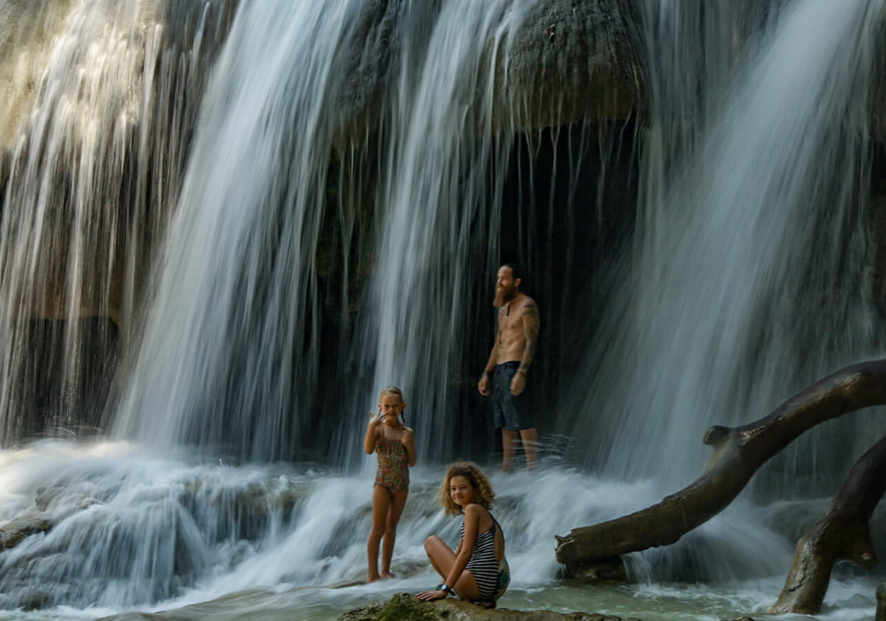 A father and his two daughters exploring the large waterfalls at Roberto Barrios Cascadas in Palenque, Mexico